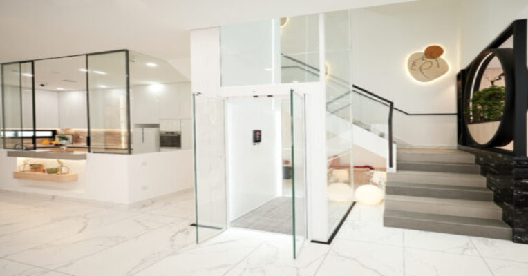 Glass panoramic home lift in modern Indian villa interior