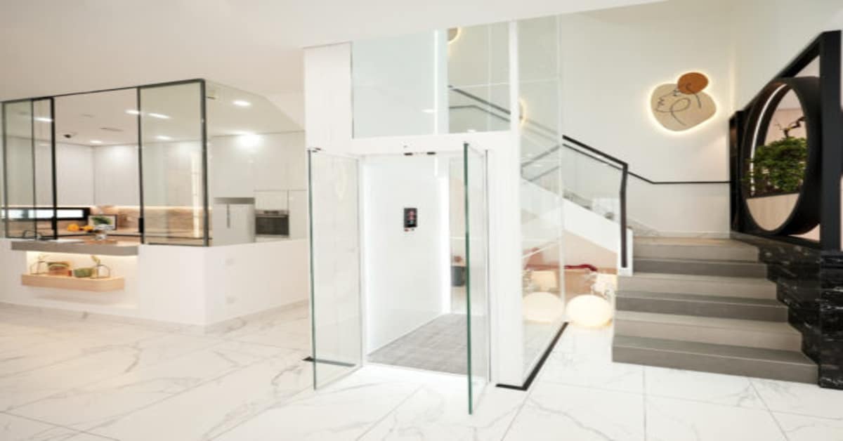 Glass panoramic home lift in modern Indian villa interior