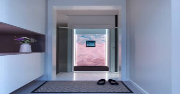 Technicus voert onderhoud uit aan een moderne huislift in een Belgische woning volgens de Belgische veiligheidswetgeving.