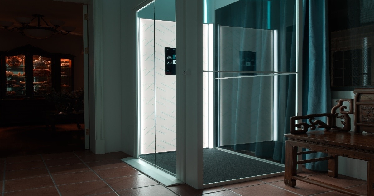 Elderly person using a modern home lift in Indonesia with safety features like battery backup, wide cabin, and easy control panel for accessibility